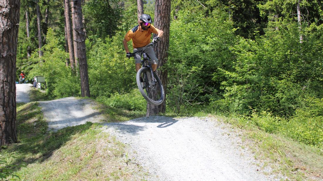 Biker springt über einen Kicker im Wald